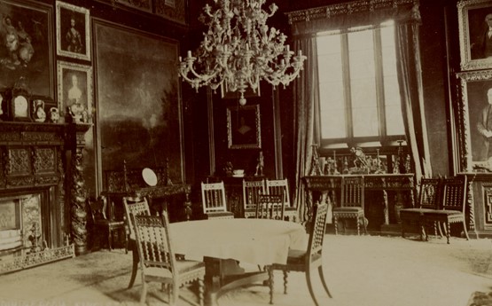 A photo of the dining room in Singleton Abbey. A table and chairs sit beneath a grand chandelier. 